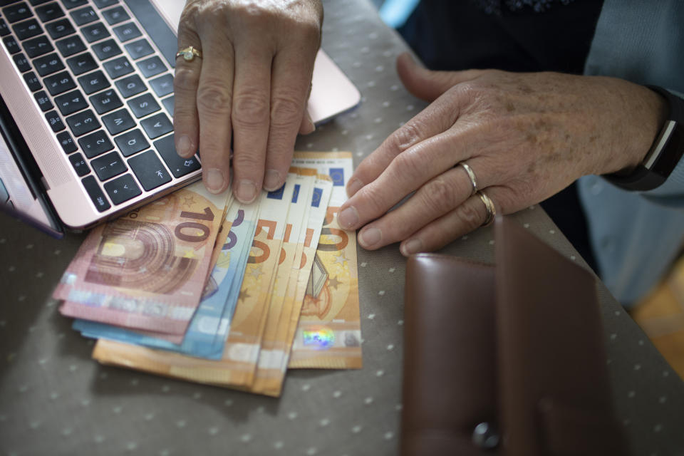 RADEVORMWALD, GERMANY - MAY 12:  In this photo illustration you find cash next to an laptop and the hands of an old woman on May 12, 2020 in Radevormwald, Germany. (Photo by Ute Grabowsky/Photothek via Getty Images)
