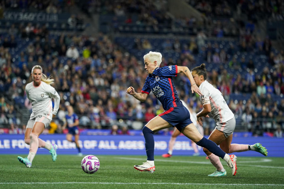 OL Reign forward Megan Rapinoe, center, makes a break for the goal against Angel City FC defender Ali Riley, right, during the first half of an NWSL quarterfinal playoff soccer match Friday, Oct. 20, 2023, in Seattle. (AP Photo/Lindsey Wasson)