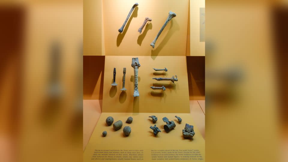 In an exhibit on Aztec musical instruments in the Hall of Mexico and South America, a display of three rasps (percussion instruments) includes a ceramic model (center top) in addition to two made from human bones (left and right, top). - American Museum of Natural History