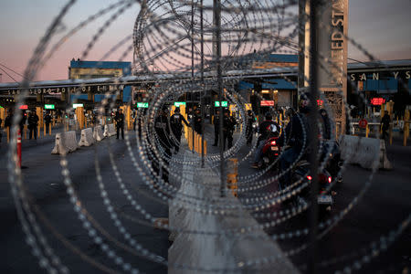U.S. Customs and Border Protection (CBP) Special Response Team (SRT) officers are seen through concertina wire after the San Ysidro Port of Entry land border crossing was temporarily closed to traffic in Tijuana, Mexico November 19, 2018. REUTERS/Adrees Latif