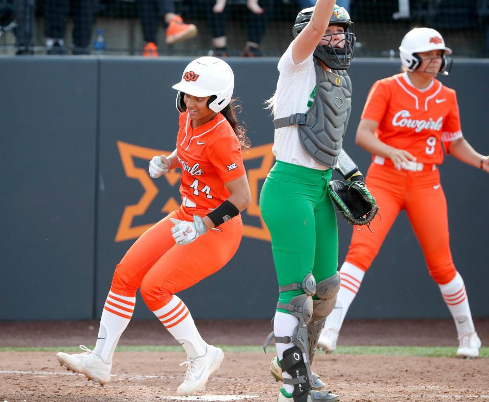 Oklahoma State's Tallen Edwards (44) runs home to score a run past Oregon's Terra McGowan (11) in the fifth inning of the second game between the Oklahoma State Cowgirls (OSU) and the Oregon Ducks in the Stillwater Super Regional of the NCAA softball tournament in Stillwater, Okla., Friday, May 26, 2023.