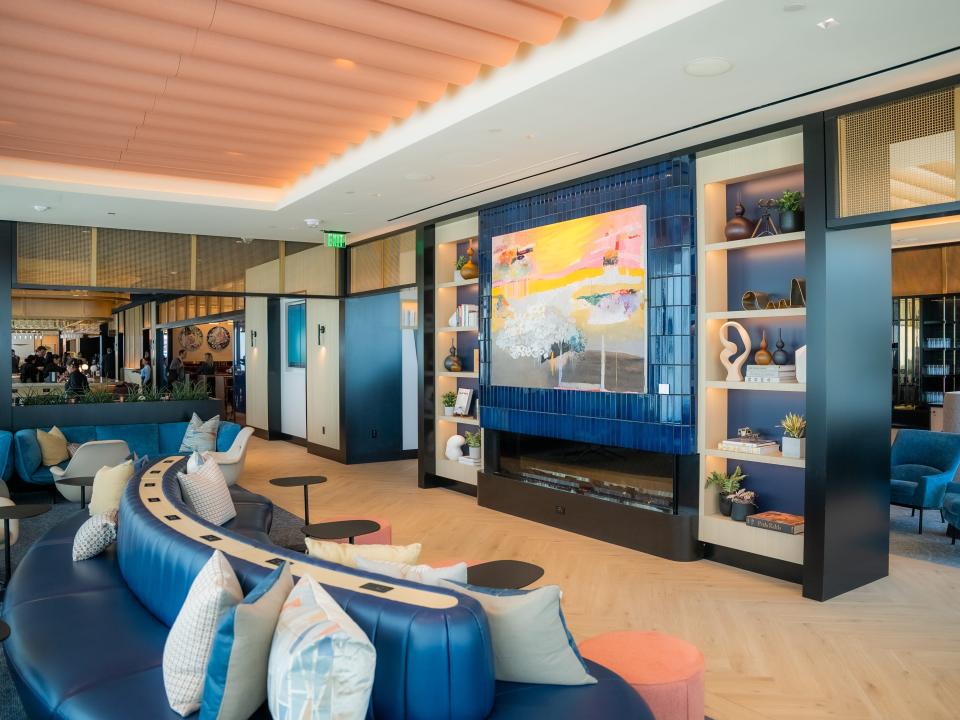 The Chase Sapphire Lounge at Boston Logan International Airport, with blue couches, clear colored pillows, and art on the walls.