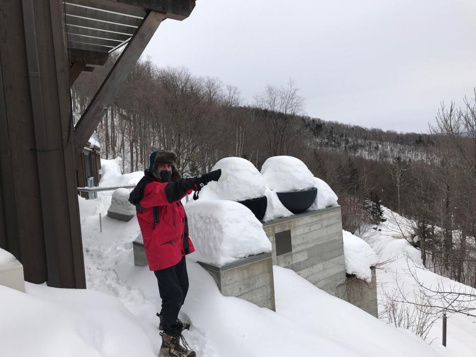 Mike Krancer points to another neighboring house from his perch atop Bull Moose Ridge Road in Stowe, Vt., on Feb. 18, 2021.