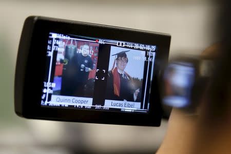 A television cameraman films a photo of Umpqua Community College shooting victims Quinn Cooper and Lucas Eibel at a media conference in Roseburg, Oregon, United States, October 3, 2015. REUTERS/Lucy Nicholson