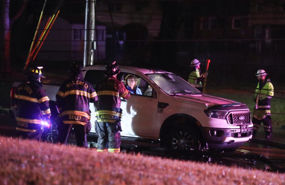 Occupants of one of two vehicles trapped by live wires are freed from their vehicles by firefighters and utility workers after downed wires along Milltown Road trapped them as a powerful storm of wind and rain hit Delaware, Tuesday, Jan. 9, 2024.