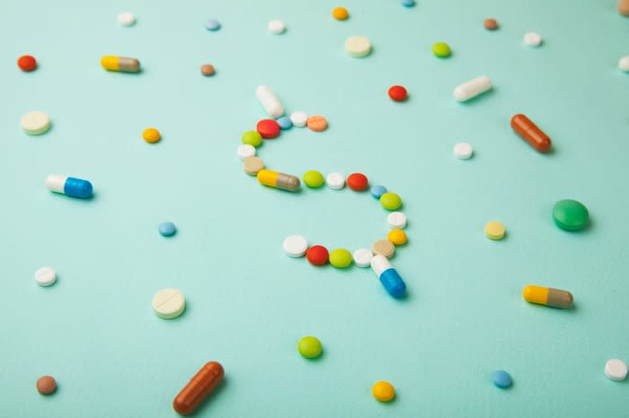 A dollar sign formed out of different-colored pills