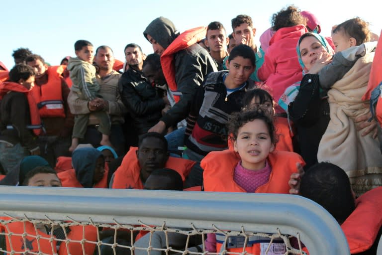 Migrants and refugees disembark from a Maltese coast guard patrol vessel after being rescued at sea, on April 15, 2016, at the Messina harbor in Sicily