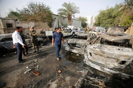 Members of Iraqi security forces look at the site after a suicide car bomb attack in Baghdad, Iraq April 29, 2017. REUTERS/Khalid al Mousily