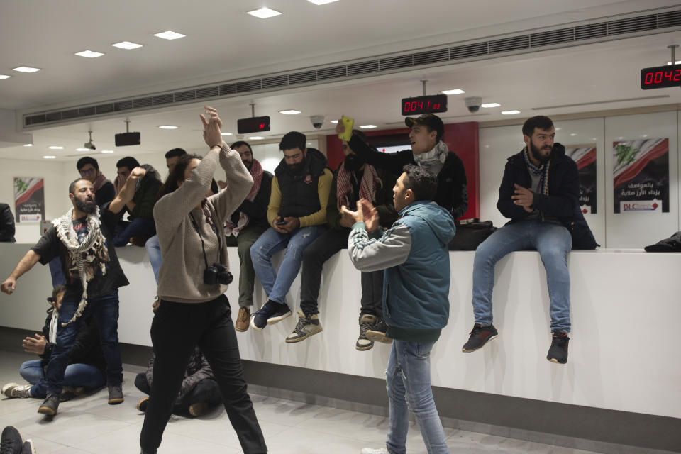 FILE - In this Dec. 28, 2019 file photo, anti-government protesters occupy the Hamra branch of BLC Bank, in Beirut, Lebanon. Riad Salameh, Lebanon’s long-serving central bank governor, was touted as the guardian of Lebanon’s monetary stability as he steered the tiny country's finances through post-war recovery and various bouts of unrest for nearly three decades. Now he is being called a “thief” by some protesters, who accuse him of being part of the ruling elite whose corruption and mismanagement has driven the country to the edge of bankruptcy. (AP Photo/Maya Alleruzzo, File)