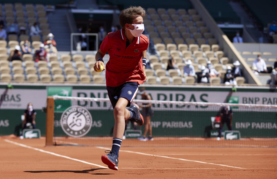 A ball boy runs with a ball during a First Round match.