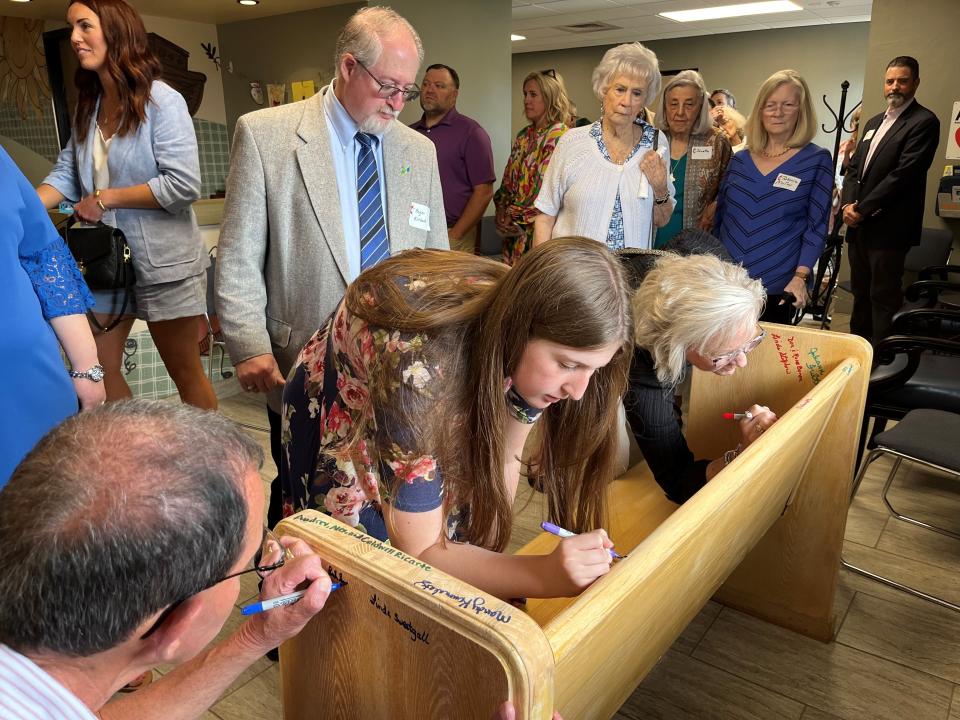 Amarillo United Methodist Church members sign a pew Charter Sunday, June 4 at St. Luke Presbyterian Church. The pew will travel with the congregation to a future church building.