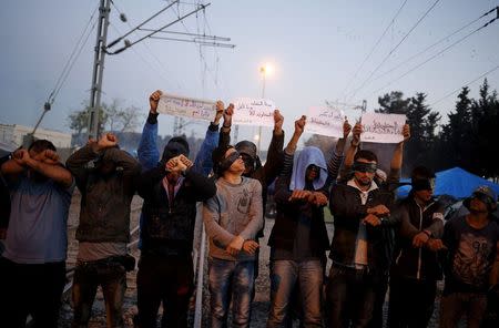 Men stage a peaceful demonstration at a makeshift camp for migrants and refugees at the Greek-Macedonian border near the village of Idomeni, Greece, April 15, 2016. REUTERS/Stoyan Nenov