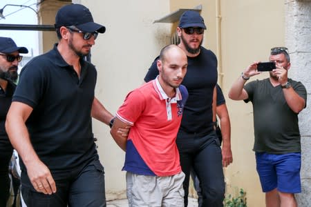 Plain-clothes police officers escort the suspect for the murder of American biologist Suzanne Eaton to the prosecutor in Chania, on the island of Crete