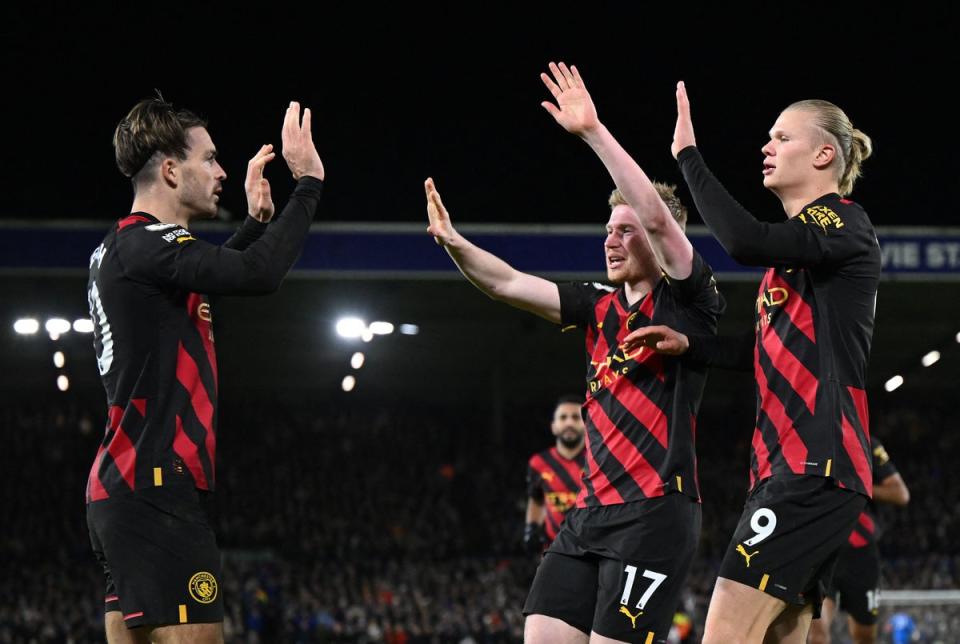 Jack Grealish celebrates with Kevin de Bruyne and Erling Haaland (AFP)