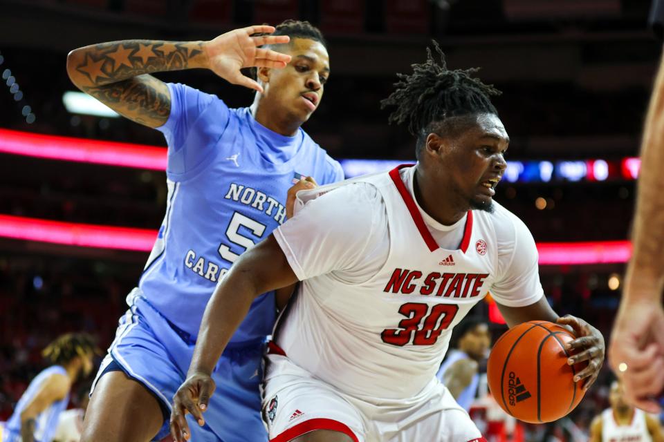 North Carolina State Wolfpack forward D.J. Burns Jr. maintains possession against North Carolina Tar Heels forward Armando Bacot during a game at PNC Arena, Feb. 19, 2023 in Raleigh, North Carolina.