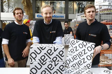 Zalando management board members Robert Gentz, Rubin Ritter and David Schneider (L-R) handle merchandising packages during the initial public offering of the company at the Frankfurt stock exchange October 1, 2014. REUTERS/Ralph Orlowski