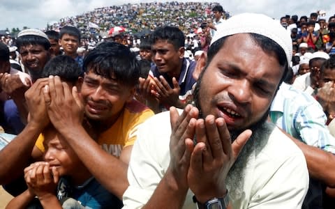 Rohingya refugees take part in a prayer as they gather to mark the second anniversary of the exodus at the Kutupalong camp in Cox's Bazaar - Credit: Reuters