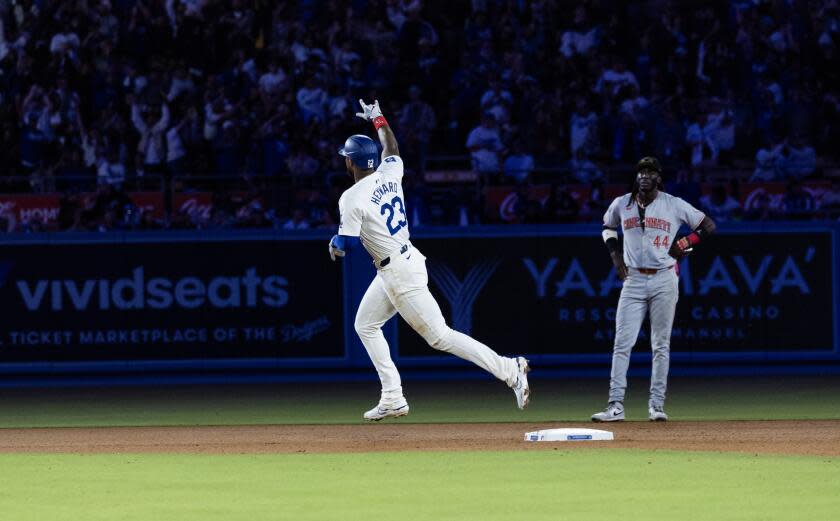 The Dodgers' Jason Heyward runs the bases in front of the Reds' Elly De La Cruz (44) after hitting a two-run homer