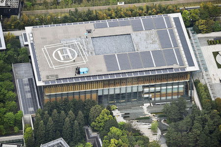 Police and security officers investigate an unidentified drone (covered under a blue sheet) which was found on the rooftop of Prime Minister Shinzo Abe's official residence in Tokyo, in this photo taken by Kyodo April 22, 2015. Mandatory credit REUTERS/Kyodo