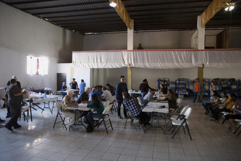 In this Oct. 26, 2019, photo, volunteer health practitioners set up a clinic in a shelter for migrants in Tijuana, Mexico. The health crisis spans both sides of the border. In the past year, at least three children, detained by U.S. Border Patrol agents, have died from the flu while being held. They include a 16-year-old boy who was seen on security footage writhing in agony on the floor in a U.S. Border Patrol holding cell. (AP Photo/Gregory Bull)