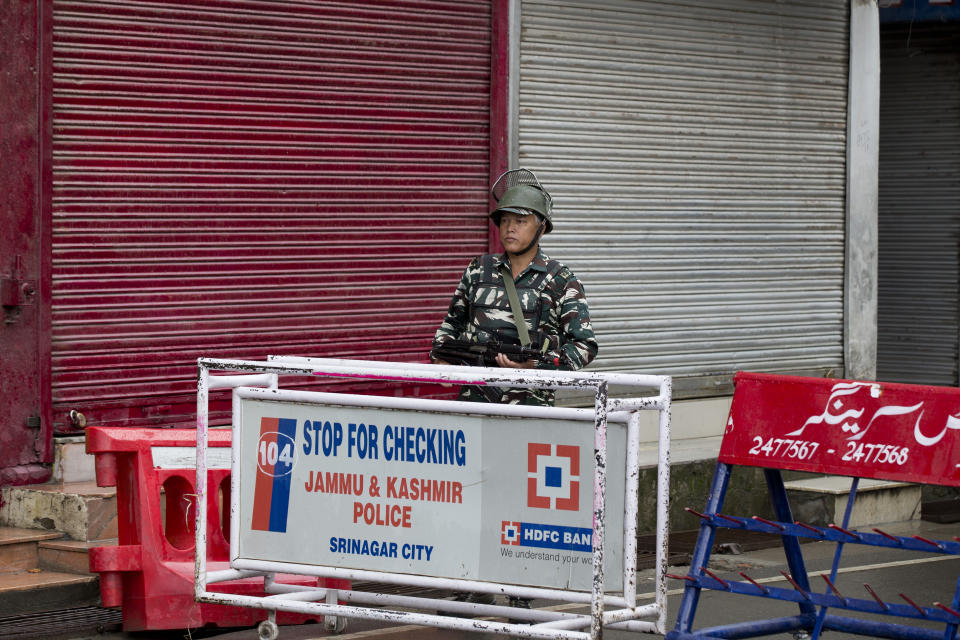 An Indian Paramilitary soldier mans a barricade on a deserted street during curfew in Srinagar, Indian controlled Kashmir, Thursday, Aug. 8, 2019. The lives of millions in India's only Muslim-majority region have been upended since the latest, and most serious, crackdown followed a decision by New Delhi to revoke the special status of Jammu and Kashmir and downgrade the Himalayan region from statehood to a territory. Kashmir is claimed in full by both India and Pakistan, and rebels have been fighting Indian rule in the portion it administers for decades. (AP Photo/Dar Yasin)