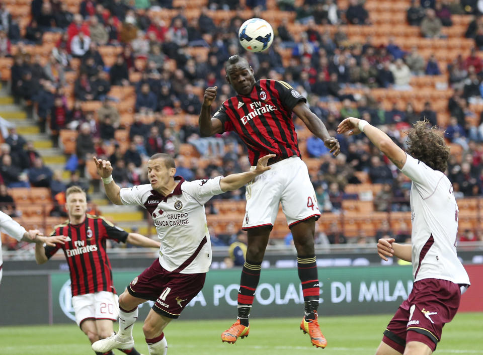 AC Milan forward Mario Balotelli, top, scores during the Serie A soccer match between AC Milan and Livorno at the San Siro stadium in Milan, Italy, Saturday, April 19, 2014. (AP Photo/Antonio Calanni)