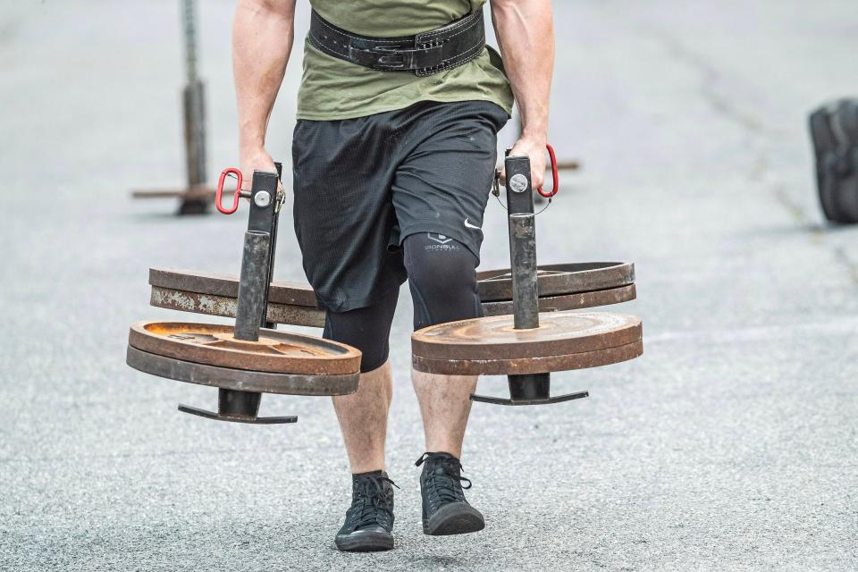 Bradie Crandall performs the farmer's walk with 450 pounds at the Training Center near New Castle on Thursday, Aug. 3, 2023. Crandall, a chemical engineering doctoral candidate at UD, is among the nation's top powerlifters and a vegan.