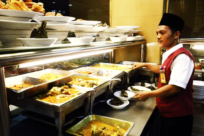 Let me serve you: A waiter showing the dishes at the Garuda Restaurant located on Jl. Hayam Wuruk. (