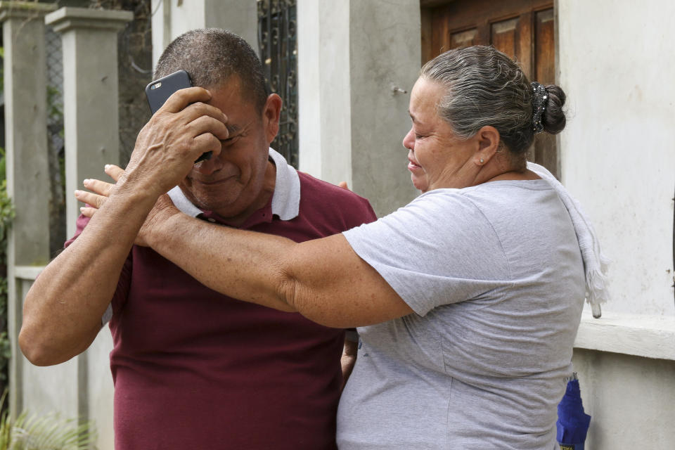 Jose Santos Bueso, father of Jazmin Nayarith Bueso, is comforted by a neighbor at his home in El Progreso, Honduras, Thursday, June 30, 2022. Nayarith Bueso was among the more than 50 migrants who were found dead inside a tractor-trailer near San Antonio, Texas. (AP Photo/Delmer Martinez)