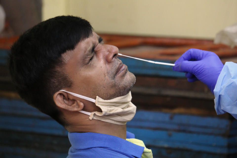 A healthcare worker collects nose-swab samples from a man during a medical check-up in Mumbai, India on July 24, 2020. India has become the third country after the United States and Brazil, to cross 01 million COVID-19 cases. (Photo by Himanshu Bhatt/NurPhoto via Getty Images)