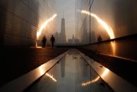 RNPS - PICTURES OF THE YEAR 2013 - A man walks through the 9/11 Empty Sky memorial at sunrise across from New York's Lower Manhattan and One World Trade Center in Liberty State Park in Jersey City, New Jersey, September 11, 2013. Americans will commemorate the 12th anniversary of the September 11 attacks with solemn ceremonies and pledges to not forget the nearly 3,000 killed when hijacked jetliners crashed into the World Trade Center, the Pentagon, and a Pennsylvania field. REUTERS/Gary Hershorn (UNITED STATES - Tags: CITYSCAPE DISASTER ANNIVERSARY TPX)
