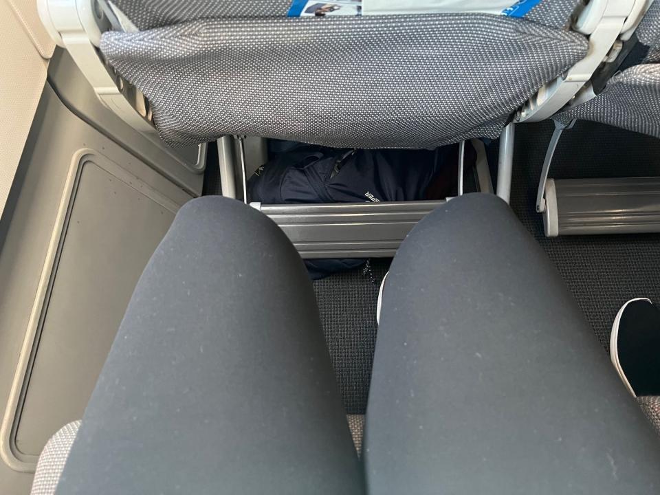 My legs showing the legroom — there is a gap between my knees and the seatback.