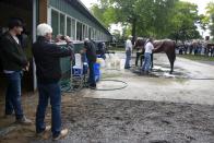 Trainer Bob Baffert takes a photo as the owners son Justin Zayat looks on as Kentucky Derby and Preakness Stakes winner American Pharoah gets bathed after his morning workout at Belmont Park in Elmont, New York June 3, 2015. REUTERS/Shannon Stapleton