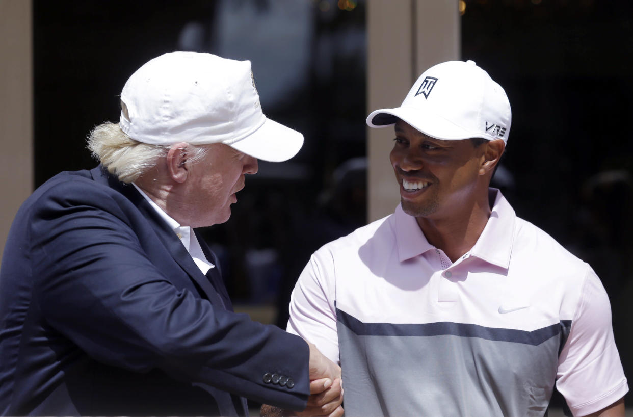 Donald Trump, left, shakes hands with Tiger Woods during a ribbon cutting for the new Tiger Woods Villa at the Trump National Doral golf course, Wednesday, March 5, 2014 in Doral, Fla. (AP Photo/Wilfredo Lee)