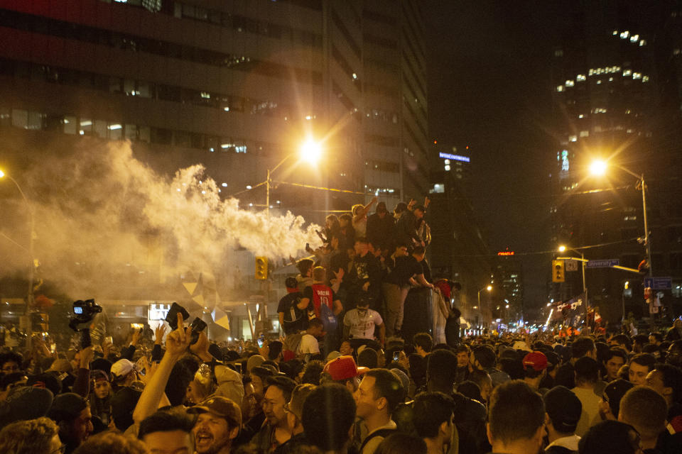Toronto Raptors fans celebrate atop a vehicle following the Raptors' defeat of the Golden State Warriors in game 6 of the NBA Finals to win the NBA Championship, in Toronto, Friday, June 14, 2019. (Chris Young/The Canadian Press via AP)