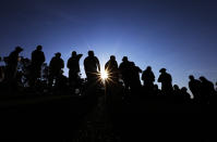 Spectators wait for golfers as the sun rises during the second round of the Masters golf tournament Friday, April 11, 2014, in Augusta, Ga. (AP Photo/David J. Phillip)