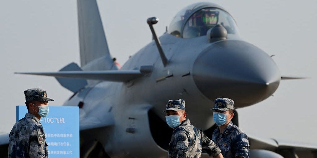 Military personnel stand in front of a Chengdu Aircraft Corporation J-10C for the People's Liberation Army Air Force (PLAAF)