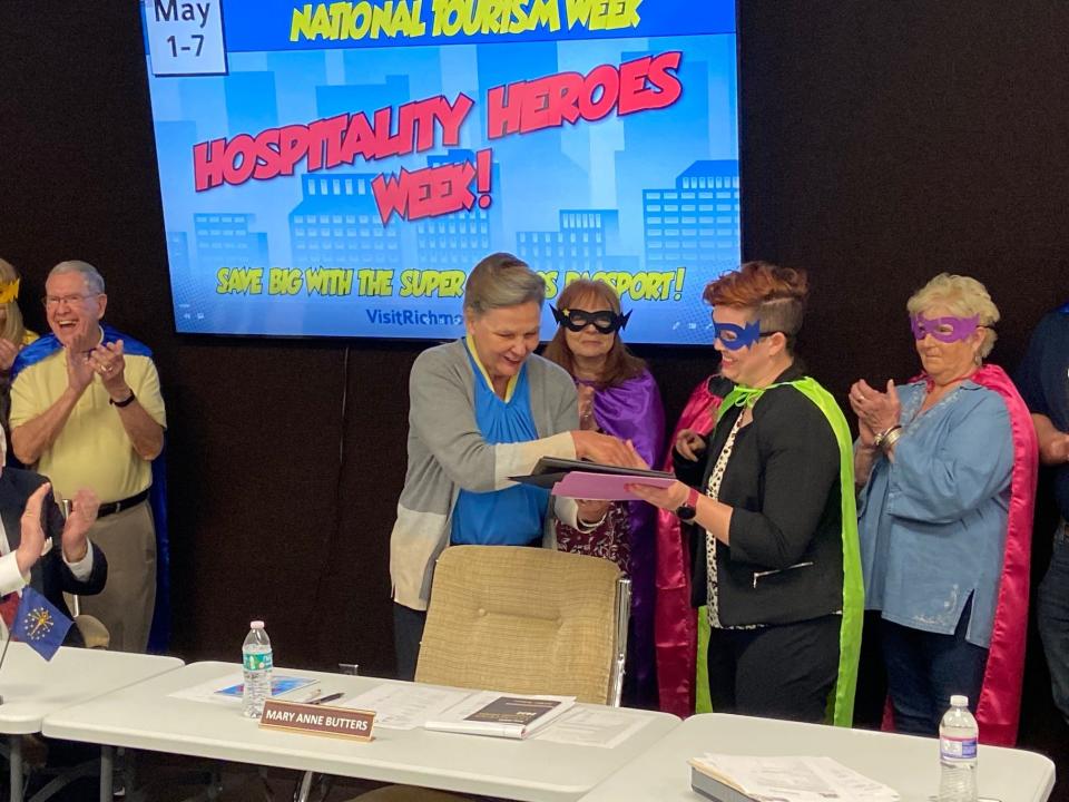 Commissioner Mary Anne Butters presents Angel Groves of the Wayne County Convention and Tourism Bureau a plaque celebrating Hospitality Heroes Week in Wayne County.