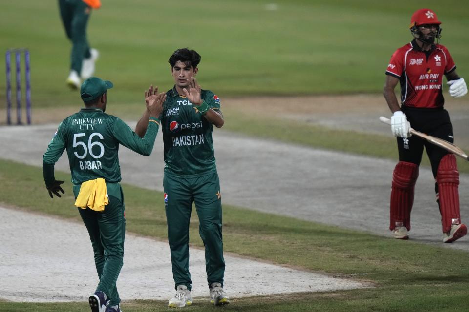 Pakistan's Naseem Shah, center, celebrates teammate after taking the wicket of Hong Kong's Nizakat Khan, right, during the T20 cricket match of Asia Cup between Pakistan and Hong Kong, in Sharjah, United Arab Emirates, Friday, Sept. 2, 2022. (AP Photo/Anjum Naveed)