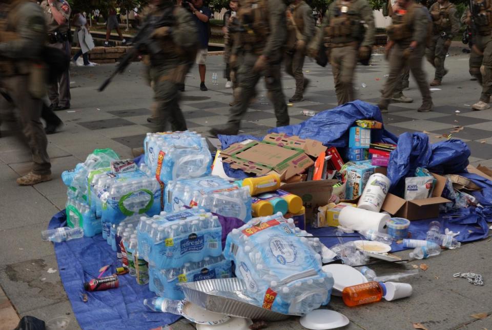 DPS officers in riot gear march past supplies provided for a pro-Palestinian encampment that was set up before dawn on May 1, 2024. Several protesters were arrested and the encampment was torn down in the afternoon.