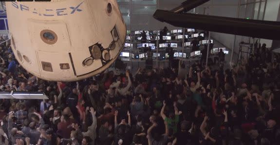 SpaceX employees at the company's Hawthorne, California headquarters celebrate the landing of a reusable Falcon 9 rocket.