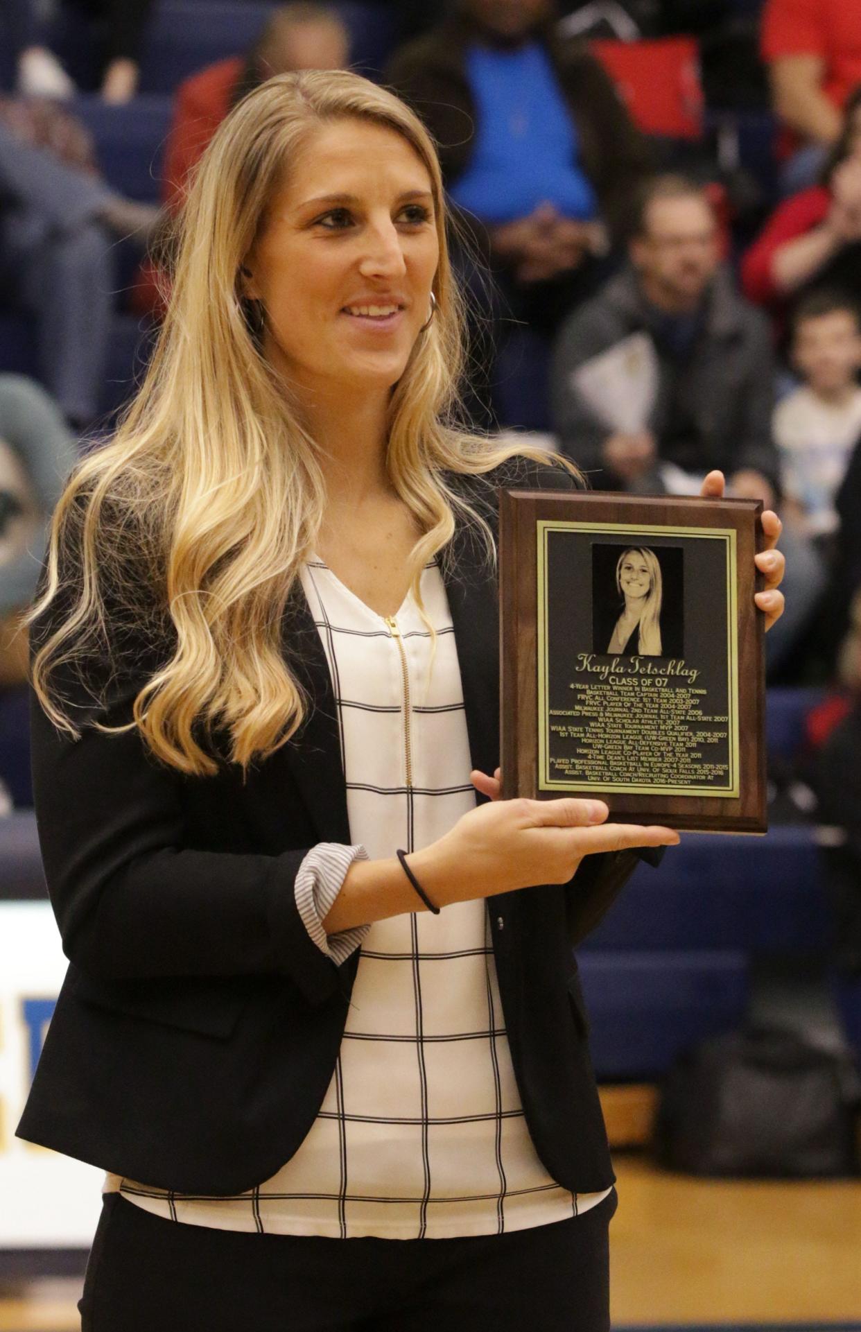 Kayla Tetschlag holds a plaque honoring her induction into the Sheboygan North Wall of Fame in December 2017.