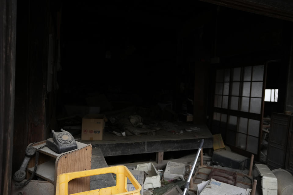 Dusted furniture and household goods are scattered in a damaged house in Futaba, northeastern Japan, Tuesday, March 1, 2022. Until recently, Futaba, home to the Fukushima Daiichi nuclear plant, has been entirely empty of residents since the March 2011, disaster. A tiny section of the town has reopened for the first time since all 7,000 residents had to flee. (AP Photo/Hiro Komae)