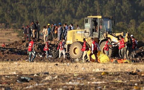 Members of the search and rescue mission carry dead bodies at the scene of the Ethiopian Airlines Flight ET 302 plane crash, near the town of Bishoftu - Credit: Reuters