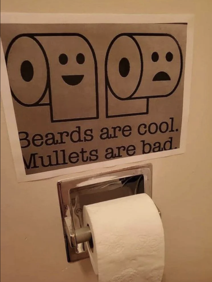 Sign reads "Beards are cool. Mullets are bad." with happy/sad face icons, above a toilet paper holder