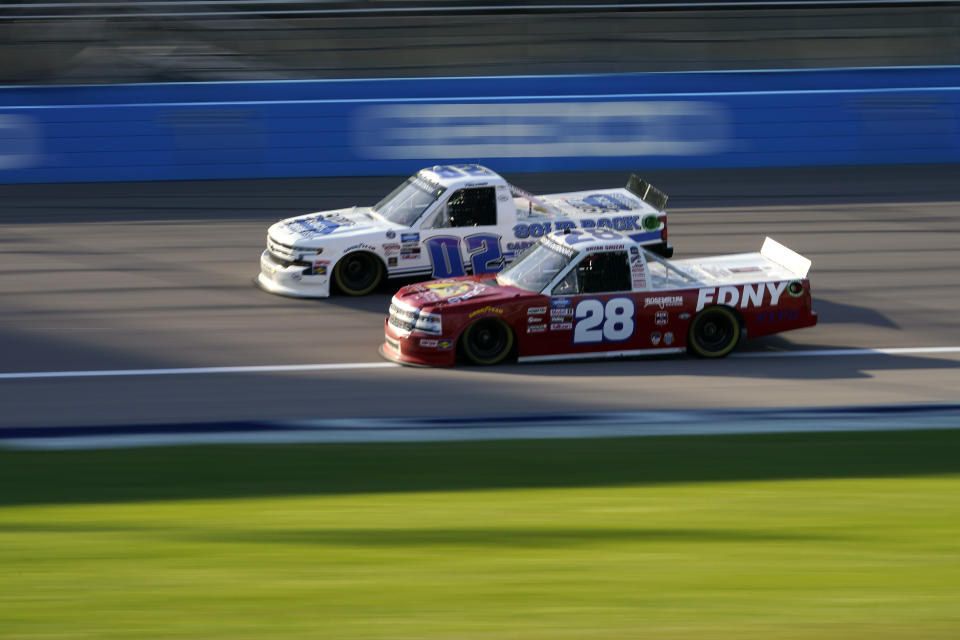 Tate Fogleman (02) and Bryan Dauzat (28) compete during a NASCAR Truck Series auto race at Kansas Speedway in Kansas City, Kan., Friday, July 24, 2020. (AP Photo/Charlie Riedel)