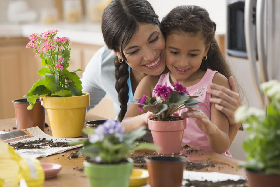 Mother and daughter planting flowers in pots