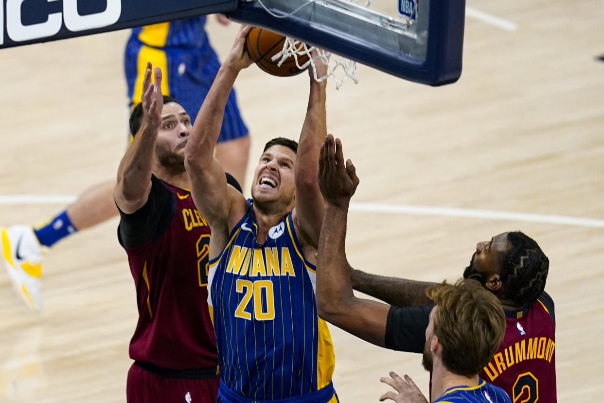 Indiana Pacers forward Doug McDermott (20) shoots between Cleveland Cavaliers forwards Larry Nance Jr. (22) and Andre Drummond during the first half of an NBA basketball game in Indianapolis, Thursday, Dec. 31, 2020. (AP Photo/Michael Conroy)