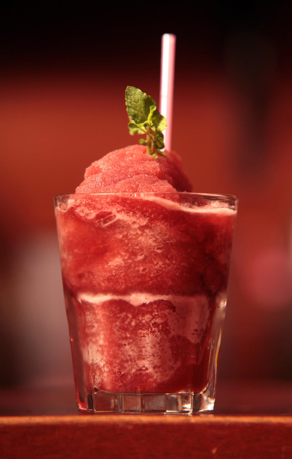 In this Tuesday, June 18, 2013 photo, a frozen cocktail named Kokroko, made with local spirit akpeteshie, sits on the bar ready to be served, at The Republic, in Accra, Ghana. In Ghana, the local alcohol akpeteshie tastes like fire to the uninitiated, burning all the way down the throat to a nervous stomach. But at The Republic in the nation’s capital, it comes garnished with mint and brown sugar for young professionals just getting off work. The drinks here represent part of a new drink movement in Ghana that some hope will spread across West Africa, taking traditional liquors and bringing them out of the countryside and into capital nightclubs. (AP Photo/Christian Thompson)