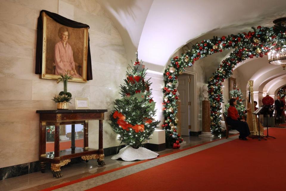 A portrait of former first lady Rosalynn Carter is draped in black bunting among the Christmas decorations at the White House in 2023